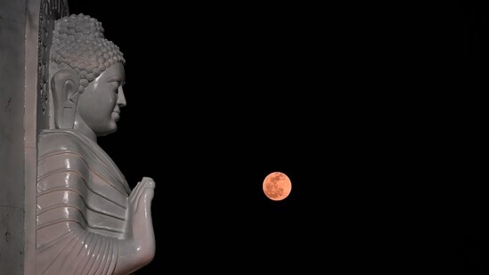 Full moon caught in the background of Gautam Buddha's statue in Lucknow on Buddha Purnima on Thursday(Deepak Gupta/HT Photo)