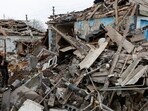 A local resident stands amid debris while carrying belongings out of a house destroyed by shelling in the course of Russia-Ukraine conflict in Donetsk.