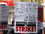 Members of the Writers Guild of America (WGA) East hold signs as they walk on the picket-line outside of the Peacock NewFront on May 02, 2023 in New York City.
