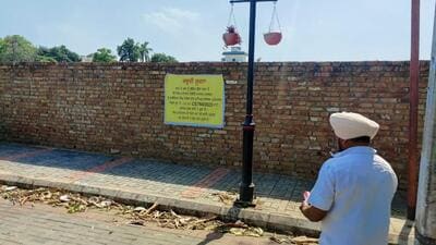 A notice put up on the boundary wall of the disputed property, stating that its sale or purchase has been stopped after a Patiala court ordered status quo. (HT Photo)
