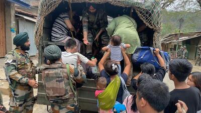 Army personnel rescue people from a violence-hit area in Manipur on Saturday. (PTI Photo)