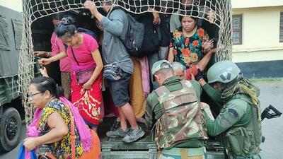 Security personnel help displaced Manipuris shift to army camps on Monday. (ANI) Security personnel help displaced Manipuris shift to army camps on Monday. (ANI)