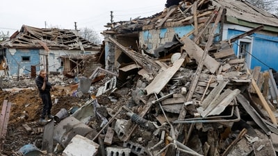 A local resident stands amid debris while carrying belongings out of a house destroyed by shelling in the course of Russia-Ukraine conflict in Donetsk. (REUTERS)