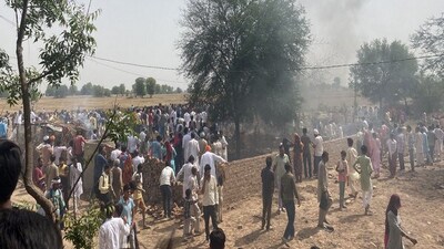 Villagers gather near the site where the IAF MiG 21 crashed in Rajasthan's Hanumangarh. (ANI)