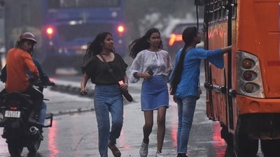 Women trying to catch a bus during rainfall. Women trying to catch a bus during rainfall.
