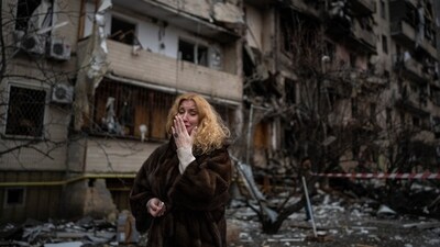 Natali Sevriukova cries in front of her apartment building destroyed in a rocket attack in Kyiv, Ukraine, on February 25, 2022. (Emilio Morenatti / AP)