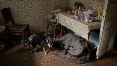 A dog stands next to the body of an elderly woman killed inside a home in Bucha on the outskirts of Kyiv, Ukraine, on April 5, 2022. (Felipe Dana / AP)