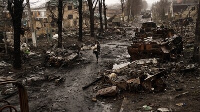 A woman walks amid destroyed Russian tanks in Bucha, on the outskirts of Kyiv, Ukraine, on April 3, 2022. (Rodrigo Abd / AP)