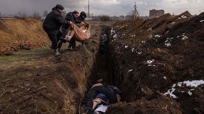 Bodies are placed into a mass grave on the outskirts of Mariupol, Ukraine, on March 9, 2022. AP's director of photography, David Ake, credited winners in the breaking news photography category for simply staying put in a war zone to bear witness. “You can’t make the moment that captures the world if you’re not there, and being there is often dirty and difficult and dangerous,” he said. (Evgeniy Maloletka / AP)