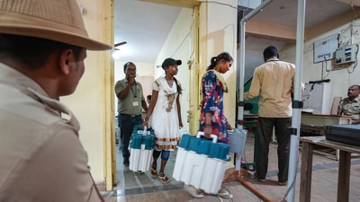 Polling officials leave for their respective polling booths after collecting EVMs ahead of the Karnataka Assembly elections in Bengaluru on Tuesday. (PTI) Polling officials leave for their respective polling booths after collecting EVMs ahead of the Karnataka Assembly elections in Bengaluru on Tuesday. (PTI)