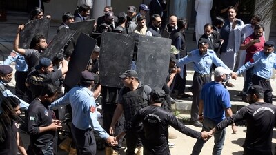 Private security personnel with bulletproof shields escort Imran Khan as he arrives to appear in a court, in Islamabad, Pakistan. (AP) Private security personnel with bulletproof shields escort Imran Khan as he arrives to appear in a court, in Islamabad, Pakistan. (AP)