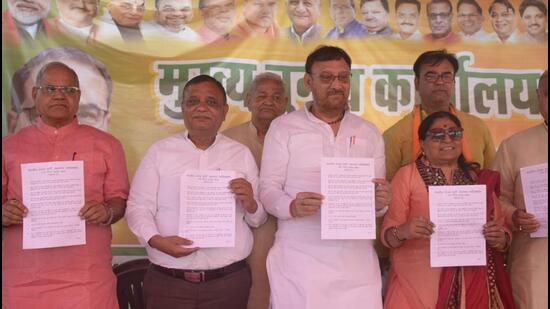 Ghaziabad BJP leaders showing show the election manifesto of BJP mayoral candidate Sunita Dayal in Raj Nagar, Ghaziabad on Tuesday. (Sakib Ali/HT Photo)