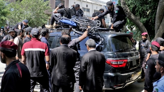 Security personnel stand guard as Pakistan's former Prime Minister Imran Khan arrives at the high court in Islamabad.(AFP)