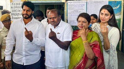 Former Karnataka CM H.D. Kumaraswamy with his family members after casting vote for Karnataka Assembly elections, at a polling station, at Bidadi in Ramanagara district. (PTI) Former Karnataka CM H.D. Kumaraswamy with his family members after casting vote for Karnataka Assembly elections, at a polling station, at Bidadi in Ramanagara district. (PTI)