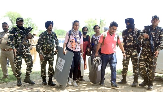 Paramilitary and police personnel escort polling officials as they leave for their respective polling booths after collecting EVMs and other voting materials on the eve of Jalandhar by-elections, in Jalandhar on Tuesday. (ANI)