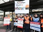 Railroad employees stand with banners on an empty platform at the main train station in Stuttgart, Germany, Railroad employees stand with banners on an empty platform at the main train station in Stuttgart, Germany,