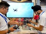 Students demonstrate a drone created by them for carrying food and medicines in emergency situations like earthquake during an exhibition on the National Technology Day, at Pragati Maidan in New Delhi, Thursday, Students demonstrate a drone created by them for carrying food and medicines in emergency situations like earthquake during an exhibition on the National Technology Day, at Pragati Maidan in New Delhi, Thursday,
