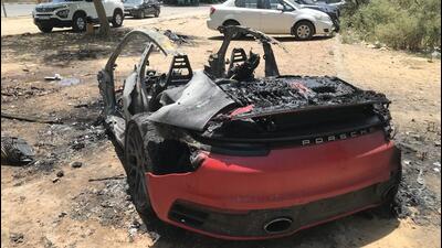 Pictures of the car were shared on social media websites on Thursday. Police said only the melted parts of the car remained. The Porsche monogram on the car’s rear end was one of the parts that remained intact. (Parveen Kumar/HT Photo)