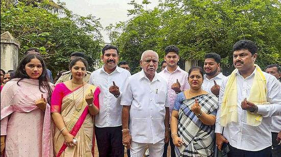 Former CM and senior BJP leader BS Yediyurappa with his family members after casting votes for Karnataka assembly elections, in Shikaripura on Wednesday. (PTI)