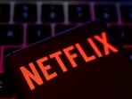 Smartphone with Netflix logo is placed on a keyboard.