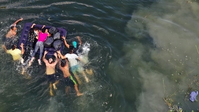 An aerial view of migrants making their way across the Rio Grande to enter the United States on May 11 in Matamoros, Mexico. A surge of migrants are expected with the end of the US government's Covid-19 era Title 42 policy, which for the past three years has allowed for the quick expulsion of irregular migrants entering the country. (Joe Raedle/ Getty Images/ AFP) An aerial view of migrants making their way across the Rio Grande to enter the United States on May 11 in Matamoros, Mexico. A surge of migrants are expected with the end of the US government's Covid-19 era Title 42 policy, which for the past three years has allowed for the quick expulsion of irregular migrants entering the country. (Joe Raedle/ Getty Images/ AFP)