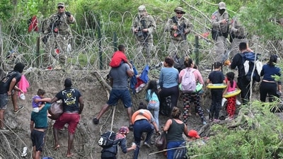 Migrants try to get to the US through the Rio Grande as seen from Matamoros in Mexico on May 11. On the day, President Joe Biden's administration will lift Title 42, the strict protocol implemented by previous president Donald Trump to deny entry to migrants and expel asylum seekers based on the Covid pandemic emergency. (Alfredo Estrella / AFP ) Migrants try to get to the US through the Rio Grande as seen from Matamoros in Mexico on May 11. On the day, President Joe Biden's administration will lift Title 42, the strict protocol implemented by previous president Donald Trump to deny entry to migrants and expel asylum seekers based on the Covid pandemic emergency. (Alfredo Estrella / AFP )
