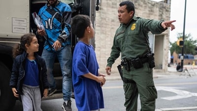 A Border Patrol agent looks on as migrant children and families get down from a bus at a processing center on May 11 in Brownsville, Texas. The Biden administration has said the new policies are meant both to crack down on illegal crossings and to offer a new legal pathway for migrants who spend thousands on smuggling operations to get them to the U.S.-Mexico border, reported AP (Andrew Caballero- Reynolds / AFP ) A Border Patrol agent looks on as migrant children and families get down from a bus at a processing center on May 11 in Brownsville, Texas. The Biden administration has said the new policies are meant both to crack down on illegal crossings and to offer a new legal pathway for migrants who spend thousands on smuggling operations to get them to the U.S.-Mexico border, reported AP (Andrew Caballero- Reynolds / AFP )