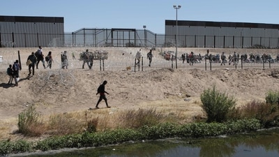 Migrants wait on the banks of the Rio Grande to be processed by the Border Patrol of El Paso Sector, Texas, after crossing from Ciudad Juarez, Mexico, on May 11. (Herika Martinez / AFP ) Migrants wait on the banks of the Rio Grande to be processed by the Border Patrol of El Paso Sector, Texas, after crossing from Ciudad Juarez, Mexico, on May 11. (Herika Martinez / AFP )
