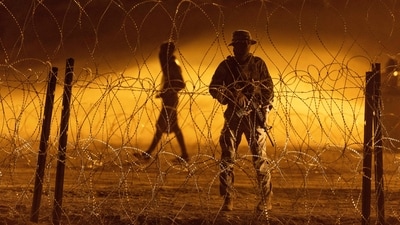 A Texas National Guard soldier stands vigil at a makeshift migrant camp near the US-Mexico border fence on May 11 in El Paso, Texas. Up to 1,000 can enter daily though land crossings with Mexico if they snag an appointment on an online app. At shelters in northern Mexico, many migrants chose not to rush to the border and waited for existing asylum appointments or hopes of reserving one online. (John Moore /Getty Images / AFP ) A Texas National Guard soldier stands vigil at a makeshift migrant camp near the US-Mexico border fence on May 11 in El Paso, Texas. Up to 1,000 can enter daily though land crossings with Mexico if they snag an appointment on an online app. At shelters in northern Mexico, many migrants chose not to rush to the border and waited for existing asylum appointments or hopes of reserving one online. (John Moore /Getty Images / AFP )