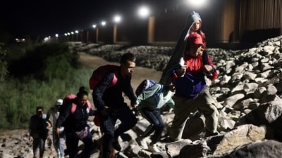 Immigrants seeking asylum in the United States walk along the border fence on their way to be processed by US Border Patrol agents in the early hours after crossing into Arizona from Mexico on May 11 in Yuma, Arizona. (Mario Tama / Getty Images) Immigrants seeking asylum in the United States walk along the border fence on their way to be processed by US Border Patrol agents in the early hours after crossing into Arizona from Mexico on May 11 in Yuma, Arizona. (Mario Tama / Getty Images)