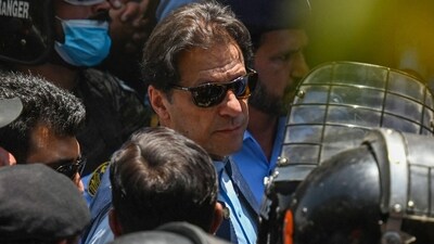 Policemen escort Pakistan's former Prime Minister Imran Khan (C) as he arrives at the high court in Islamabad on Friday. (AFP) Policemen escort Pakistan's former Prime Minister Imran Khan (C) as he arrives at the high court in Islamabad on Friday. (AFP)