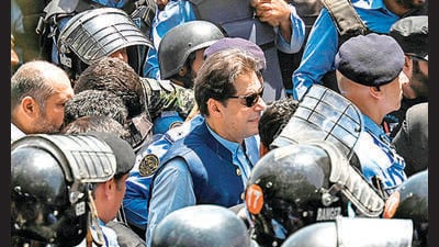 Policemen escort Pakistan's former Prime Minister Imran Khan as he arrives at the high court in Islamabad on Friday. (AFP) Policemen escort Pakistan's former Prime Minister Imran Khan as he arrives at the high court in Islamabad on Friday. (AFP)