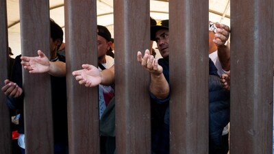 Migrants reach for water through the Mexico - U.S. border wall in San Luis Rio Colorado in Mexico, before the lifting of Title 42, as seen from San Luis, Arizona, U.S., May 11, 2023. (REUTERS)