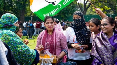 Congress supporters celebrate with sweets the party's good show in Karnataka Assembly polls at the AICC headquarters in New Delhi. (PTI)