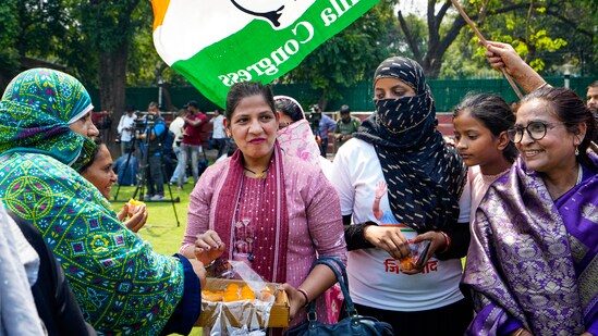 Congress supporters celebrate with sweets the party's good show in Karnataka Assembly polls at the AICC headquarters in New Delhi.(PTI)