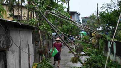 A resident walks past the fallen trees after Cyclone Mocha crashed ashore, in Kyauktaw in Myanmar’s Rakhine state on Sunday. (AFP) A resident walks past the fallen trees after Cyclone Mocha crashed ashore, in Kyauktaw in Myanmar’s Rakhine state on Sunday. (AFP)