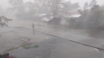 A man stands during strong winds and heavy rainfall at ThekayPyin Rohingya camp, as Cyclone Mocha approaches, in Sittwe, Rakhine, Myanmar, (via REUTERS)