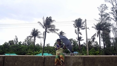 A boy holds an umbrella while he sits on an embankment in Shahpori island on the outskirts of Teknaf. (AFP) A boy holds an umbrella while he sits on an embankment in Shahpori island on the outskirts of Teknaf. (AFP)