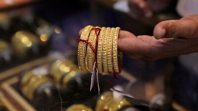 A salesperson shows gold bangles to a customer at a jewellery showroom during Dhanteras, a Hindu festival associated with Lakshmi, the goddess of wealth, in Mumbai, India, (File) (REUTERS)