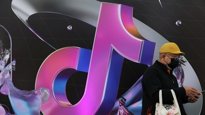 A man stands near a sign of ByteDance app Douyin. (REUTERS)