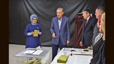Turkish President Recep Tayyip Erdogan, center, and his wife Emine, left, prepare to cast their ballots at a polling station in Istanbul, Sunday, May 14, 2023 (AP) Turkish President Recep Tayyip Erdogan, center, and his wife Emine, left, prepare to cast their ballots at a polling station in Istanbul, Sunday, May 14, 2023 (AP)