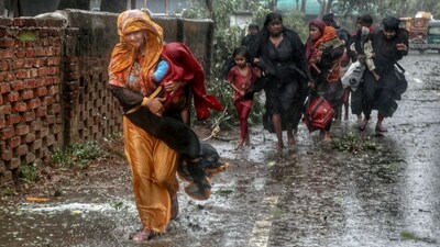 People move from their homes to take shelter in the nearest cyclone shelter at Shah Porir Dwip during the landfall of cyclone Mocha in Teknaf, on May 14. Deputy refugee commissioner Shamsud Douza told AFP, "About 300 shelters were destroyed by the cyclone," and the damage was also minimal in the Rohingya camps, where about a million people live in 190,000 bamboo and tarpaulin shelters. (Jibon Ahmed / Reuters) People move from their homes to take shelter in the nearest cyclone shelter at Shah Porir Dwip during the landfall of cyclone Mocha in Teknaf, on May 14. Deputy refugee commissioner Shamsud Douza told AFP, "About 300 shelters were destroyed by the cyclone," and the damage was also minimal in the Rohingya camps, where about a million people live in 190,000 bamboo and tarpaulin shelters. (Jibon Ahmed / Reuters)