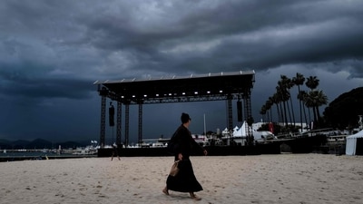 A woman walks on the beach in front of the stage of the ‘Cinema de la plage’ ahead of the 76th Cannes Film Festival, All protests are banned around the Croisette during the event, local authorities told AFP, adding that this was the same as previous years. (Valery Hache / AFP) A woman walks on the beach in front of the stage of the ‘Cinema de la plage’ ahead of the 76th Cannes Film Festival, All protests are banned around the Croisette during the event, local authorities told AFP, adding that this was the same as previous years. (Valery Hache / AFP)