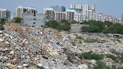 A tractor driver illegally dumps construction and demolition (C&D) waste on a vacant land near an electricity substation in Sector-52, in Gurugram on Saturday. (Parveen Kumar/HT Photo)