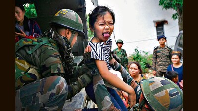 Army personnel help a girl onto a truck after reuniting her with her parents in Manipur. (AFP) Army personnel help a girl onto a truck after reuniting her with her parents in Manipur. (AFP)