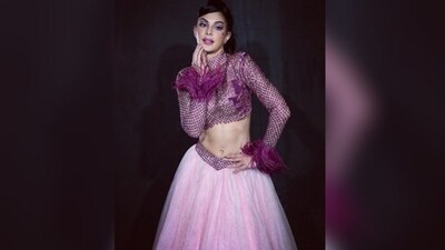For her first look, Jacqueline exuded elegance in a stunning ensemble by Falguni Shane Peacock. She showcased her fashion prowess in a purple crop top with a high neck, full sleeves adorned with fur detailing, and exquisite embellishments throughout. To complement the top, she paired it with a graceful light pink organza skirt. (Instagram/@jacquelinef143) For her first look, Jacqueline exuded elegance in a stunning ensemble by Falguni Shane Peacock. She showcased her fashion prowess in a purple crop top with a high neck, full sleeves adorned with fur detailing, and exquisite embellishments throughout. To complement the top, she paired it with a graceful light pink organza skirt. (Instagram/@jacquelinef143)