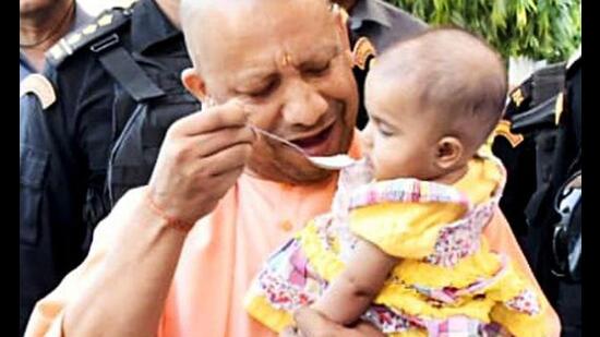 Uttar Pradesh chief minister Yogi Adityanath offers Annaprashan to a six-month-old baby girl during his visit to Gorakhnath temple, in Gorakhpur on Monday. (ANI Photo)