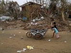 Children push a cart full of debris at the Khaung Dote Khar Rohingya refugee camp in Sittwe, in Myanmar's Rakhine state, on Monday.