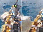 The video shows a shark attacking a fisherman's kayak in Hawaii.