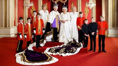 Britain's King Charles III wearing the Imperial State Crown and Britain's Queen Camilla posing in the Throne Room at Buckingham Palace in London with their Pages of Honour and Ladies in Attendance. (AFP)